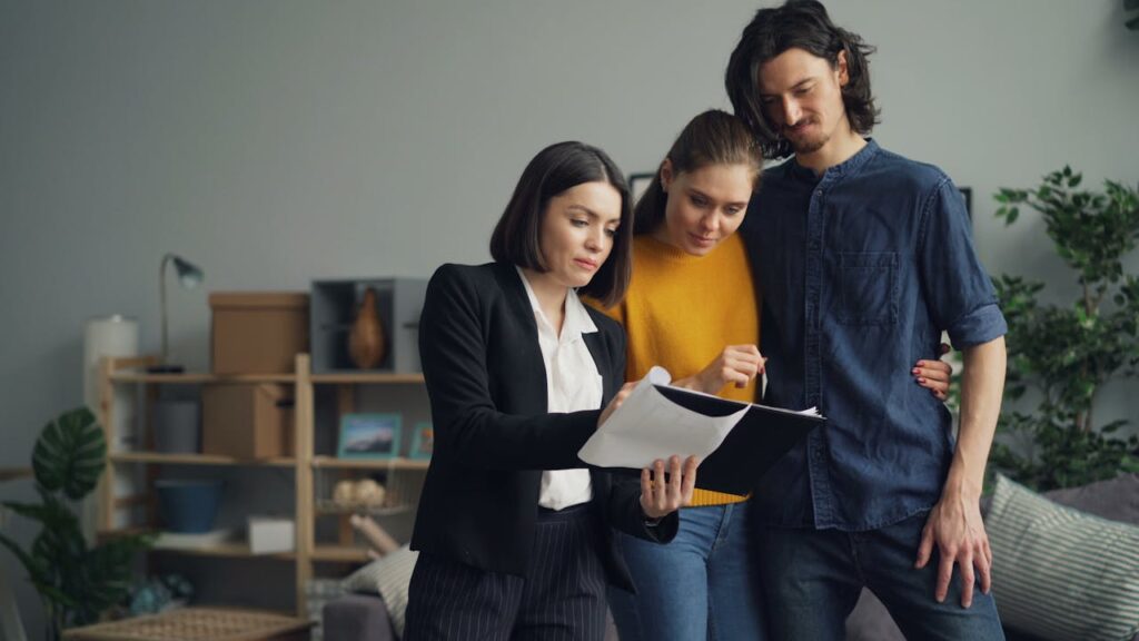 pexels-photo-23224993 Young couple consulting with a real estate agent about property one indoors.