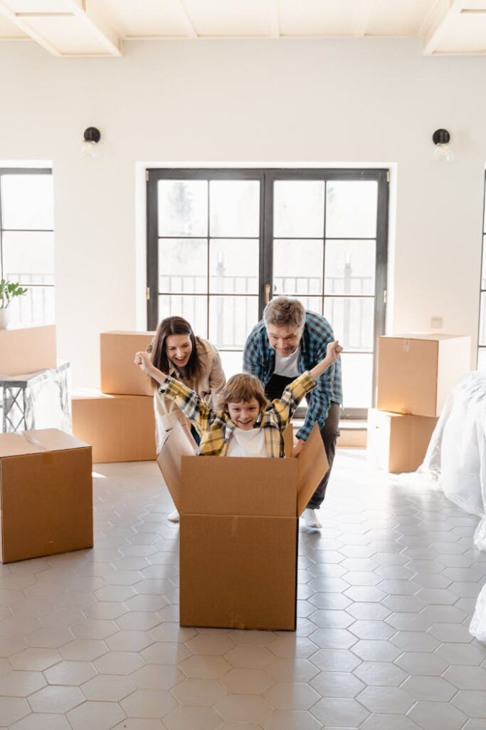 pexels-photo-7415127 Happy family celebrating move into new home with unpacked boxes.